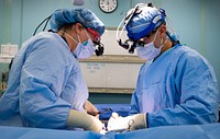 USNS Comfort (T-AH 20) Performs Surgery 200417-N-EV253-1331 NEW YORK (April 17, 2020) - Plastic surgeon Capt. Lauren Archer, left, and neurosurgeon Lt. Cmdr. Scott Zuckerman, collaborate during a surgical procedure aboard the hospital ship USNS Comfort (T-AH 20).