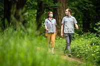 Couple with face coverings walking in nature, Oregon. Original public domain image from <a href="https://www.flickr.com/photos/usforestservice/50040682322/" target="_blank">Flickr</a>