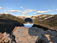 Glass globe reflecting the Grand Tetons. Original public domain image from Flickr