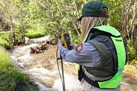 Park hydrologist, Erin White, taking high-precision water velocity measurements in Reese Creek by Jacob W. Frank. Original public domain image from Flickr