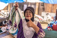 Muslim woman holding fish. Ikan segar di pasar Donggala