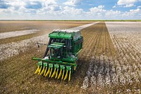 Aerial view of a cotton picking harvester, during the Ernie Schirmer Farms cotton harvest which has family, fellow farmers, and workers banding together for the long days of work, in Batesville, TX, on August 23, 2020.USDA Photo and Media by Lance Cheung. Original public domain image from Flickr