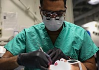 Makin Island Underway 210121-N-NY430-1010 INDIAN OCEAN (Jan. 21, 2021) – U.S. Navy Hospital Corpsman 3rd Class Tyus Haynes performs a dental cleaning aboard the amphibious assault ship USS Makin Island (LHD 8).