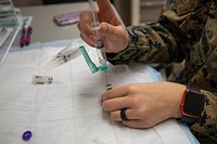 CAMP PENDLETON, Calif. (March 11, 2021) A U.S. Navy Corpsman draws a COVID-19 vaccine from a vial during a SHOTEX at Camp Pendleton, California. US Marine Corps photo by Lance Cpl. Abigail Paul. Original public domain image from Flickr
