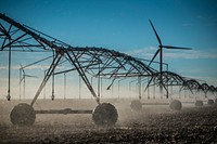 In irrigation pivot on a field in Burley, Idaho with wind turbines in the background. Near W 500 S and S 400 W streets. 10/8/2018 Photo by Kirsten Strough. Original public domain image from <a href="https://www.flickr.com/photos/usdagov/51039326698/" target="_blank" rel="noopener noreferrer nofollow">Flickr</a>