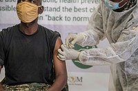 A Ugandan soldier serving under the African Union Mission in Somalia (AMISOM) takes the COVID-19 jab at the launch of the COVID-19 vaccination campaign in Mogadishu, Somalia on 17 May 2021. AMISOM Photo/Mokhtar Mohamed. Original public domain image from Flickr