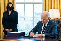 President Joe Biden, joined by Vice President Kamala Harris, signs H.R. 1319, the “American Rescue Plan Act of 2021” Thursday, March 11, 2021, in the Oval Office of the White House. (Official White House Photo by Adam Schultz). Original public domain image from Flickr