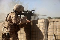 U.S. Marine Corps Sgt. Corey Sherwood provides cover fire for Marines assigned to an explosive ordinance disposal unit in Sangin, Afghanistan, Nov. 9, 2010.