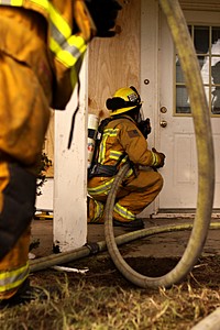 Marine Corps firefighters get the job done, Calif.-Firefighters from Camp Pendleton Fire Department and North County Area Fire Departments prepare to demonstrate a firefighting technique called positive pressure attack during simulated fire scenarios in the old base housing units at Naval Weapons Station Fallbrook.