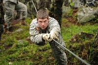US Army Sgt. Johnathan Oberholz, an infantryman with C-Troop, 2-106th Cavalry Squadron, Aurora, Illinois, crosses a one-rope bridge during an infantry subject matter expert exchange at the 6th Battalion of &quot;Casadores&quot; training area in Constanza, Dominican Republic on June 8, 2011.