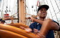 U.S. Coast Guard Academy Fourth Class Cadet Tevin Porter-Perry, 17, of Hampton, Va., turns the helm aboard the Coast Guard Cutter Eagle Monday, July 25, 2011. Porter-Perry is one of 104 fourth class cadets who reported aboard the Eagle as part of their indoctrination into the U.S. Coast Guard Academy, which is also known as Swab Summer. U.S. Coast Guard photo by Petty Officer 1st Class NyxoLyno Cangemi. Original public domain image from Flickr