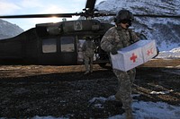 U.S. Army Spc. Errol Sahagun, assigned to the 12th Combat Aviation Brigade, carries supplies from a UH-60A Black Hawk helicopter to deliver to citizens in Montenegro stranded by severe weather Feb. 23, 2012.