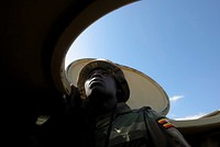 A Ugandan gunner serving with the African Union Mission in Somalia (AMISOM) looks out from the gun turret of an armoured personnel carrier 20 January, during a firefight following an advance with the Somali National Army (SNA) to capture Mogadishu University in insurgent Al Shabaab territory.