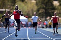 U.S. Marine Corps Cpl. Kionte Storey runs across the finish line in the men's 100-meter lower impairment dash race during the track and field portion of the 2012 Warrior Games at the United States Air Force Academy in Colorado Springs.