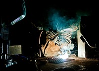 Welder demonstrates basic welding techniques for his partnered trainees. Original public domain image from Flickr