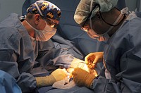 U.S. Navy Cmdr. Matthew Provencher, right, the director of surgical services, assisted by Capt. Todd Simmonson, perform surgery aboard Military Sealift Command hospital ship USNS Mercy (T-AH 19) Aug. 14, 2012, in the Pacific Ocean, during Pacific Partnership 2012.