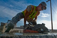 Senior Airman Andrew Higginbotham, a heavy equipment and pavements journeyman assigned to the 99th Civil Engineer Squadron , uses a concrete saw to cut out a piece of curb during the construction of a parking lot, Aug. 15, 2012, at Nellis Air Force Base, Nev. (DoD photo by Airman 1st Class Daniel Hughes, U.S. Air Force/Released).