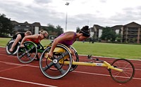 Hannah McFadden, right, a U.S. Paralympian, trains with her track and field teammates, Amberlynn Webber, center, and Austin Pruitt, at the fitness center track at RAF Lakenheath, England, Aug. 20, 2012.