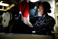 U.S. Navy Seaman Sackiema Thomas sews bunting in the sail loft aboard the aircraft carrier USS Nimitz (CVN 68) at Naval Station Everett, Wash., Sept. 7, 2012.