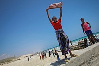 A Somali boy holds a shirt aloft to dry in the wind at Lido Beach in the Abdul-Aziz district of the Somali capital Mogadishu 09 November 2012.