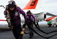 130201-N-XE109-003 ATLANTIC OCEAN (Feb. 01, 2013) Aviation Boatswain's Mate (Fuels) Airman Gavin Snyder, left, and Aviation Boatswain's Mate (Fuels) 1st Class Mark Davidson pull a fuel hose across the flight deck of the aircraft carrier USS George H.W. Bush (CVN 77).