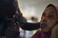 An army medic checks a patient's eyes at a medical outreach centre in the Somali capital Mogadishu as part of the Tarehe Sita celebrations, which commemorates the formation of the modern-day Ugandan army, the Ugandan People's Defense Forces (UPDF) on 06 February 1981.