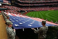 U.S. Airmen with the 375th Air Mobility Wing present a giant U.S. flag for nearly 50,000 fans to see at Busch Stadium in St. Louis, Mo., April 8, 2013.
