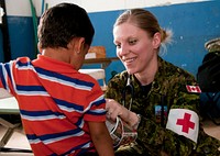 Canadian Forces Capt. Karoline Martin, a nurse with the Canadian Forces Health Services Center, gives a child a sticker after an examination during a medical clinic April 15, 2013, in Caluco, El Salvador, as part of Beyond the Horizon (BTH) 2013.