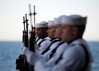 U.S. Sailors with the rifle detail aboard the aircraft carrier USS Carl Vinson (CVN 70) stand at attention during a burial at sea ceremony April 18, 2013, in the Pacific Ocean.