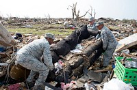 From left, U.S. Air Force Master Sgt. Dante Alexander, Tech. Sgt. Anthony Burch and Chief Master Sgt. Kevin Vegas, all assigned to Tinker Air Force Base, Okla., help clean up a damaged home in Moore, Okla., May 24, 2013.