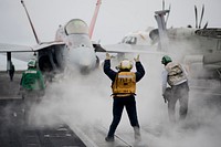 U.S. Navy Aviation Boatswain's Mate 2nd Class Tamara Sewell, center, directs an F/A-18C Hornet aircraft assigned to Strike Fighter Squadron (VFA) 94 to a catapult on the flight deck of the aircraft carrier USS Carl Vinson (CVN 70) in the Pacific Ocean June 10, 2013.