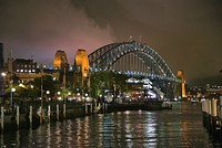 Sydney by night.The Sydney Harbour Bridge is a steel through arch bridge across Sydney Harbour that carries rail, vehicular, bicycle, and pedestrian traffic between the Sydney central business district and the North Shore. Original public domain image from Flickr