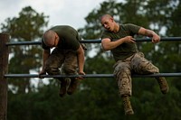 U.S. Marine Corps recruit Caleb McCready, left, and recruit Mark Fiasconaro, both with Platoon 3060, Kilo Company, 3rd Recruit Training Battalion, flip over a set of double bars on an obstacle course, June 10, 2013, at Parris Island, S.C. The obstacle course was a combat conditioning tool used to build Marine Corps recruits' strength and stamina.