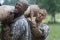 U.S. Army Pvt. Jeremiah Joliff, left, and Spc. Michael Hill, assigned to the 3rd Squadron, 1st Cavalry Regiment, 3rd Armored Brigade Combat Team, 3rd Infantry Division, carry a log during a spur ride event at Fort Benning, Ga., June 19, 2013.