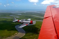 A retired U.S. Navy T-6 Texan trainer aircraft, left, flies beside a retired Navy C-45 Expeditor during the Salute from the Shore Independence Day event July 4, 2013, near Myrtle Beach, S.C. (DoD photo by Airman 1st Class Jonathan Bass, U.S. Air Force/Released).