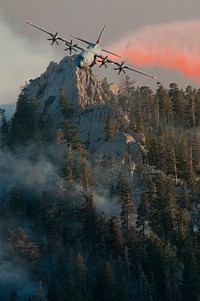 A U.S. Air Force C-130 Hercules aircraft assigned to the 146th Airlift Wing, California Air National Guard releases fire retardant over the trees in the mountains above Palm Springs, Calif., July 19, 2013.