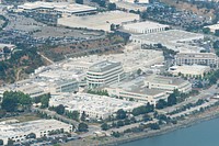 Aerial view of Genentech buildings and Forbes Blvd along South San Francisco coastline.