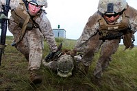 U.S. Marine Corps Lance Cpl. Rob Magnuson, left, and Lance Cpl. Rafael Cortez, right, drag Lance Cpl. Jeff Landis, a simulated casualty, while conducting combat first aid training Aug. 5, 2013, during Khaan Quest 2013 at Five Hills Training Area, Mongolia.