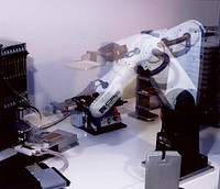 The robot made by CRS Inc. in action, places a DNA sample plate onto a plate washer for purification of the DNA, in the sequencing process.