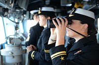 U.S. Navy Lt. j.g. Stephanie Conte, right, assigned to the guided missile cruiser USS Antietam (CG 54), stands watch as officer of the deck in the bridge as the ship arrives in Busan, South Korea, Oct. 4, 2013.