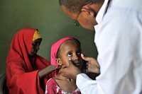 A doctor examines a young girl&#39;s eyes at a hospital run by Dr. Hawa in the Afgoye corridor of Somalia on September 25. Original public domain image from <a href="https://www.flickr.com/photos/au_unistphotostream/10439683385/" target="_blank">Flickr</a>