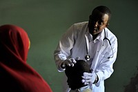 A doctor looks at a cut on a young boy&#39;s head at a hospital run by Dr. Hawa in the Afgoye corridor of Somalia on September 25. Original public domain image from <a href="https://www.flickr.com/photos/au_unistphotostream/10439809043/" target="_blank">Flickr</a>