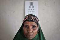 Maryanne Abdi Ali, a 59 year old woman suffering from cataracts, stands in front of an eye chart at an AMISOM medical center in Mogadishu, Somalia, on December 11. AU UN IST PHOTO / Tobin Jones. Original public domain image from Flickr