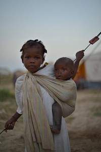 A young girl with her baby brother in an IDP camp near the town of Jowhar, Somalia, on December 14. Original public domain image from <a href="https://www.flickr.com/photos/au_unistphotostream/11401484285/" target="_blank">Flickr</a>