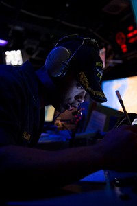 U.S. Navy Lt. j.g. Gerald Sellars stands watch as the ballistic missile defense officer during a ballistic missile defense exercise in the combat information center aboard the guided missile destroyer USS Stout (DDG 55) in the Mediterraneasn Sea Jan. 8, 2014.