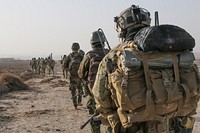 A U.S. Special Forces Soldier with Combined Joint Special Operations Task Force-Afghanistan and Afghan National Army Commandos with the 3rd Company, 3rd Special Operations Kandak move toward a compound during a clearance operation in Bahlozi, Maiwand district, Kandahar province, Afghanistan, Jan. 1, 2014.