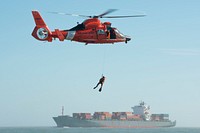 U.S. Coast Guard Petty Officer 3rd Class Andrew Wilson, a rescue swimmer with Air Station Houston, dangles from an HH-65 Dolphin helicopter above Galveston Bay in Texas during hoist training Jan. 9, 2014.