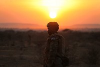 An AMISOM soldier belonging to the Djiboutian contingent of the mission stands guard as the sun sets over their position in Eel Jaale on February 7. AU UN IST PHOTO / Ilyas A. Abukar. Original public domain image from Flickr