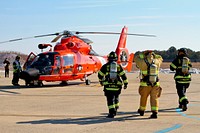 U.S. Air Force fire protection specialists from the New Jersey Air National Guard's 177th Fighter Wing prepare to extract aviators from an MH-65D Dolphin helicopter during an air mishap exercise at Coast Guard Air Station Atlantic City on Feb. 11, 2014.