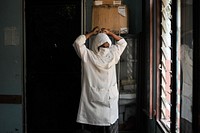 A nurse at Madina Hospital in Mogadishu, Somalia, puts on a face mask before attending to a patient in the hospital's ER on February 20. AU UN IST PHOTO / Tobin Jones. Original public domain image from Flickr